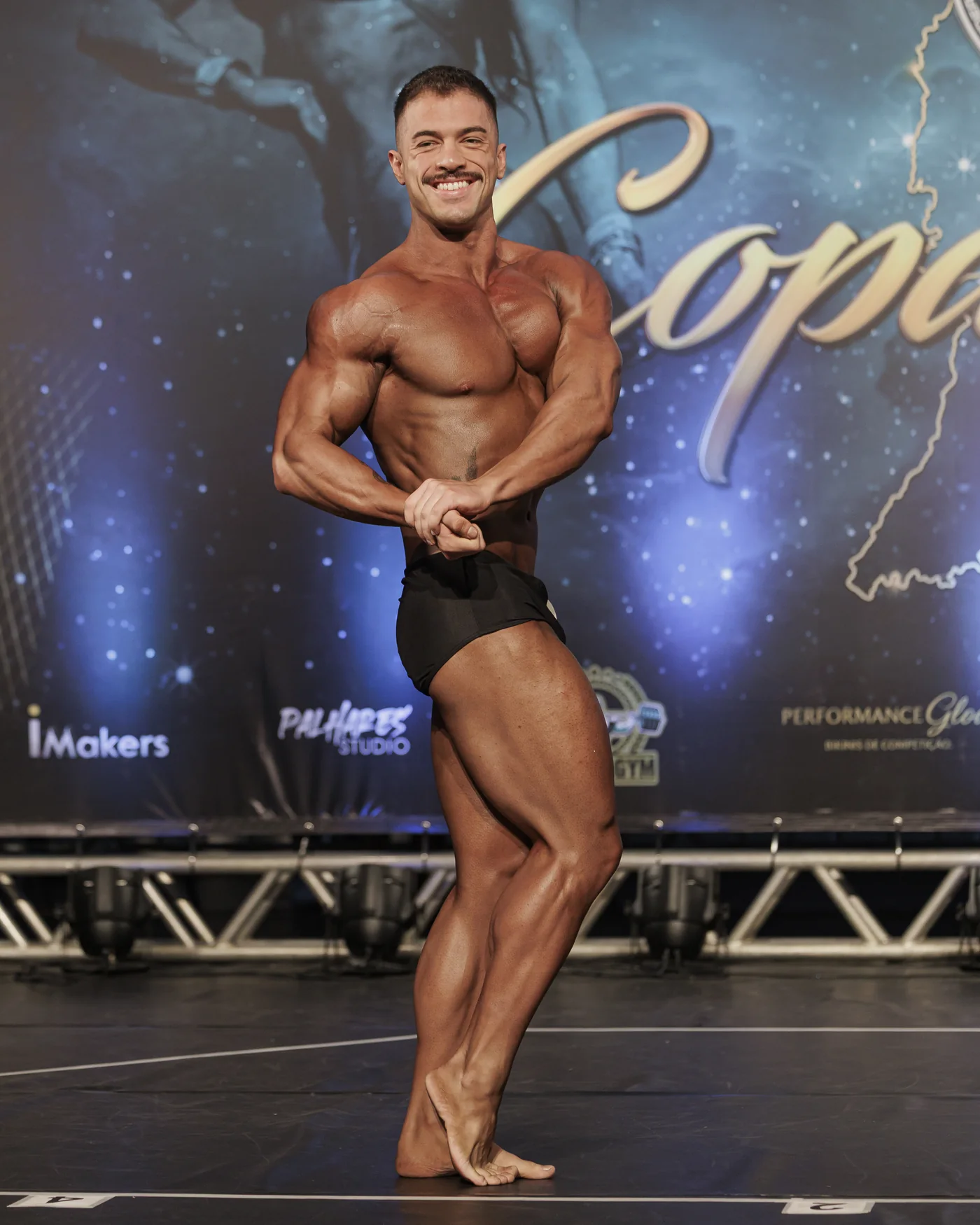 Guilherme Theulen em pose de competição no palco